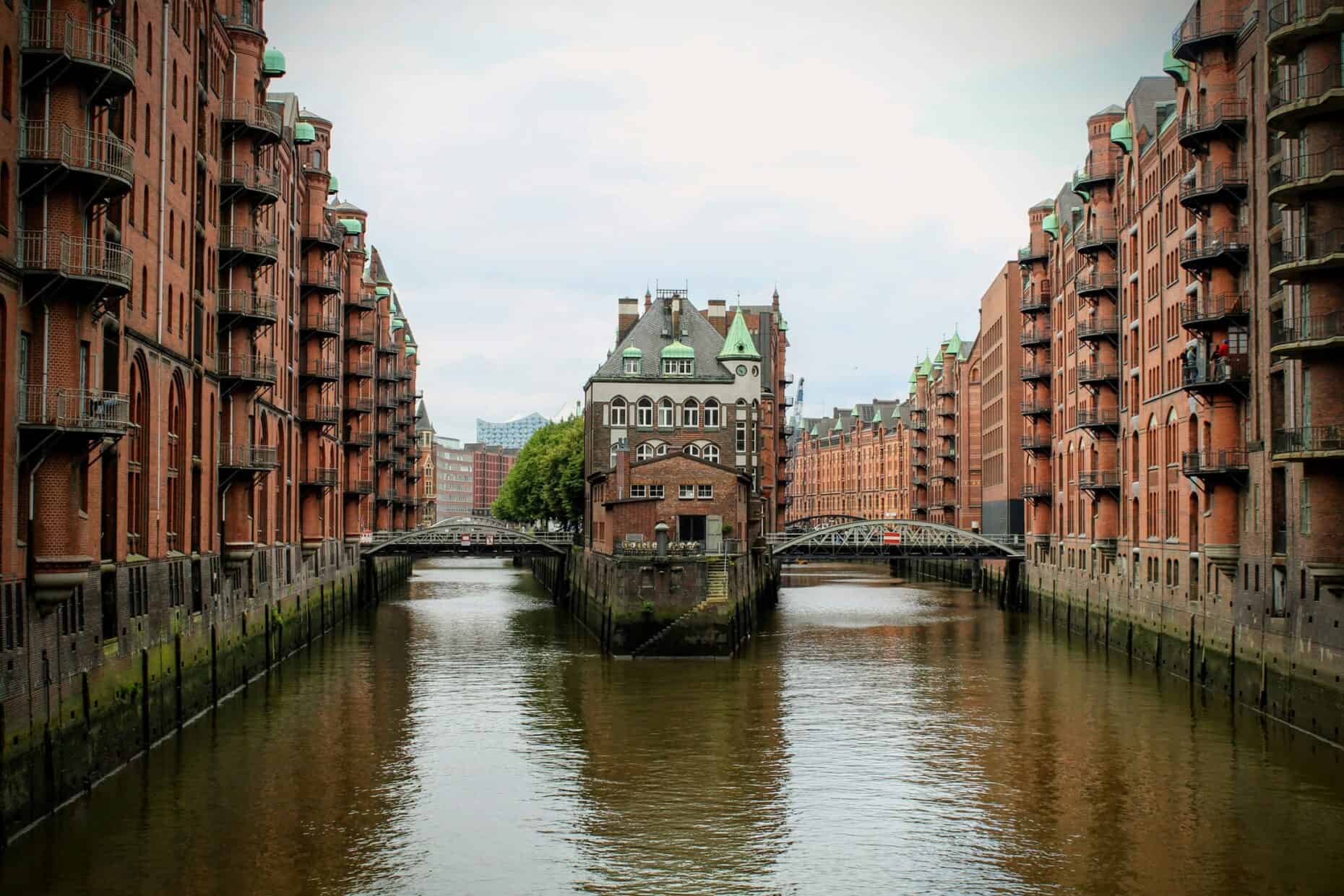 Blick auf die Hamburger Speicherstadt mit Fluss und Backsteingebäuden.