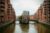 Blick auf die Hamburger Speicherstadt mit Fluss und Backsteingebäuden.