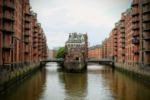 Blick auf die Hamburger Speicherstadt mit Fluss und Backsteingebäuden.