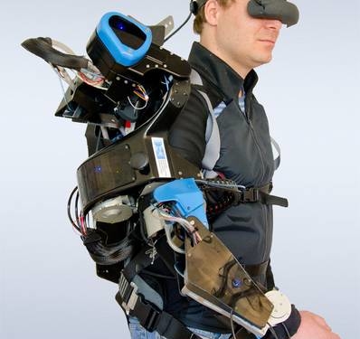 Ein Mann mit einer VR-Brille und verschiedenen Verkabelungen am Arm.