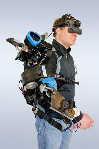 Ein Mann mit einer VR-Brille und verschiedenen Verkabelungen am Arm.