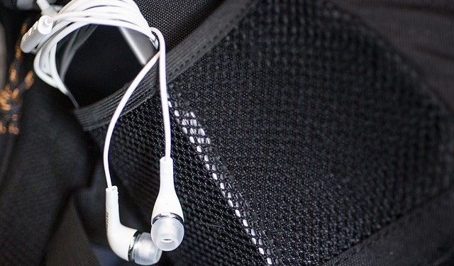 Ein MP3-Player mit Kopfhörern steckt in einer Seitentasche