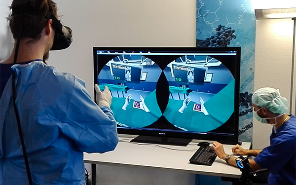 Ein Chirurg steht mit VR-Brille vor einem PC auf dem eine simulierte OP zu sehen ist.