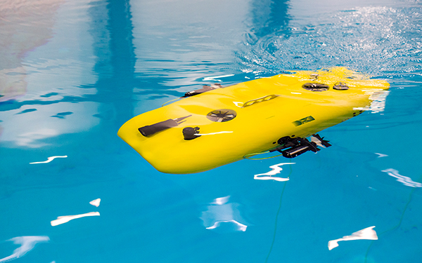 Ein gelbes, autonomes Unterwasserfahrzeug in einem Wasserbecken.