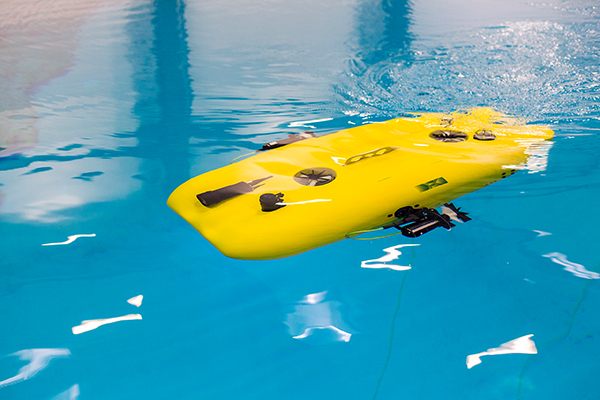 Ein gelbes, autonomes Unterwasserfahrzeug in einem Wasserbecken.