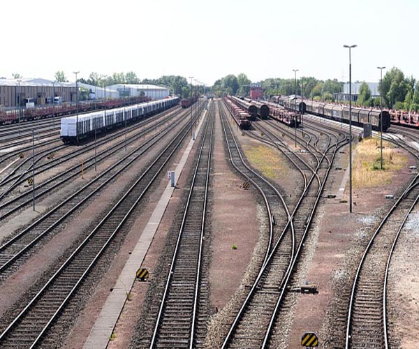 Mehrere Schienenstrecken nebeneinader, auf denen teilweise Züge stehen.