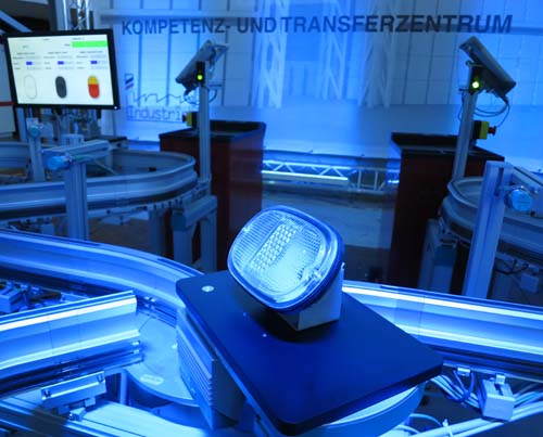 Versuchsaufbau mit einem Monitor und Kameras, die mit blauem Licht bestraht werden.