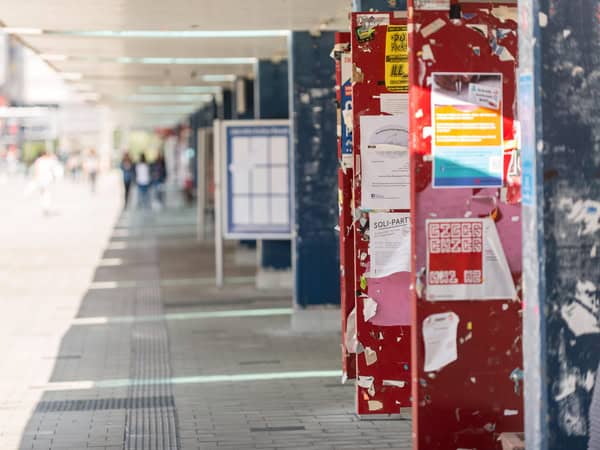 Flucht eines Fußgängerwegs auf einem Campus mit roten und blauen Säulen auf der rechten Seite