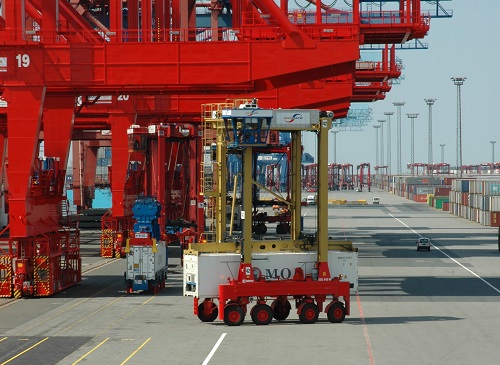 Ein Fahrzeug bewegt einen Container in einem Hafen.