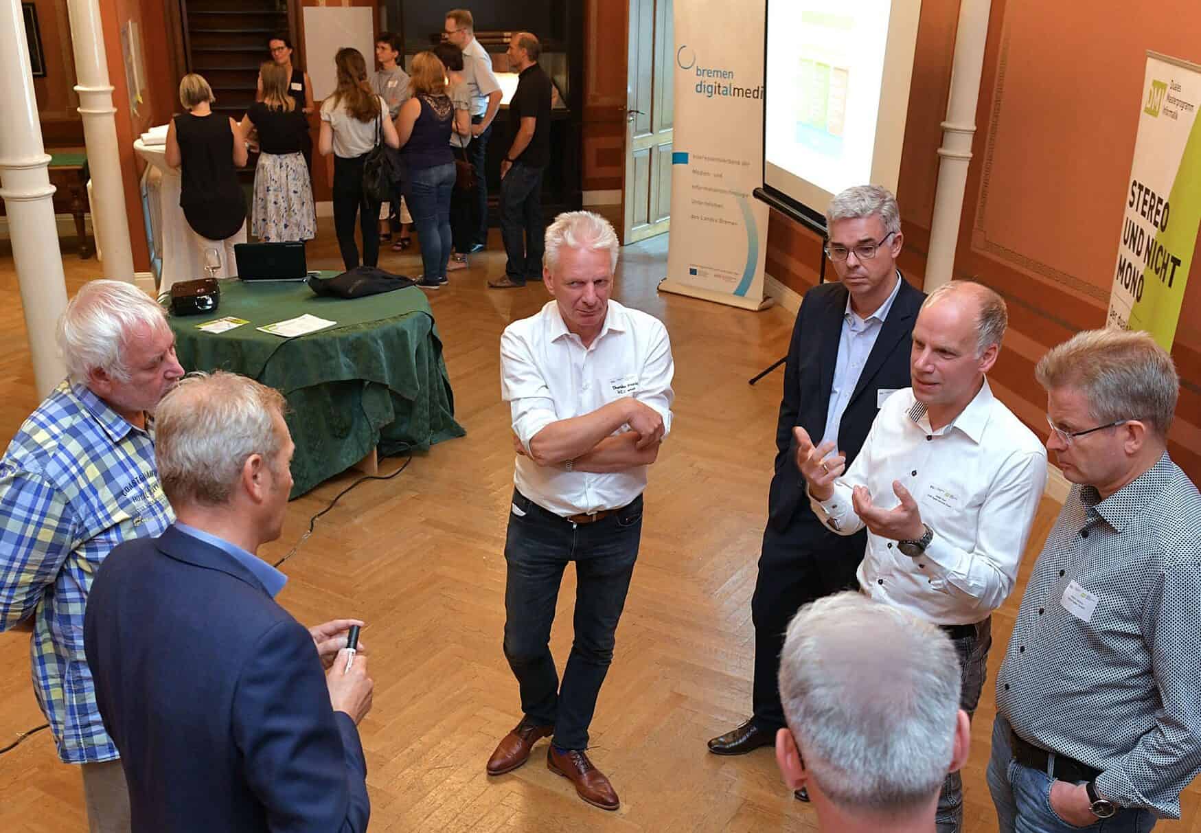 Eine Gruppe Männer steht im Kreis und tauscht sich aus.