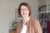 Eine Frau lächelt für ein Foto in die Kamera.