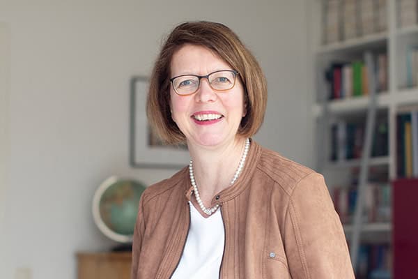 Eine Frau lächelt für ein Foto in die Kamera.
