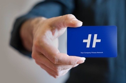 Eine Hand hält eine blaue Visitenkarte mit einem Logo darauf.