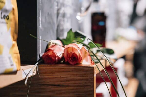Zwei Rosen liegen auf einem Holzkasten.
