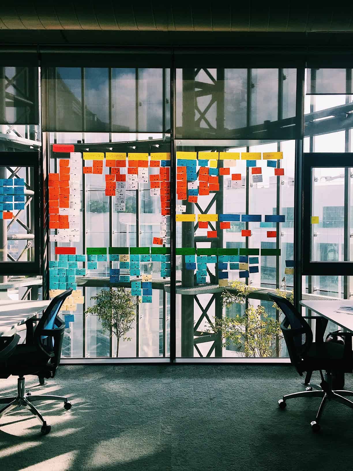 Viele bunte Klebezettel am Fenster in einem Büro