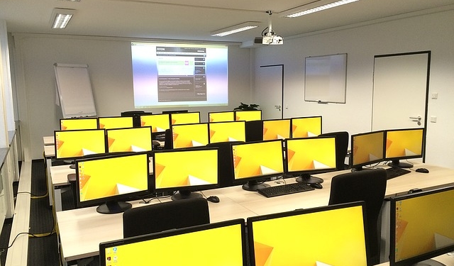 Schulungsraum mit vielen Computerbildschirmen.