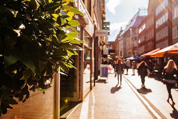 Menschen laufen eine Einkaufsstraße entlang