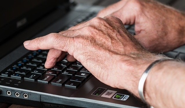 Zwei Hände liegen auf einer Tastatur.
