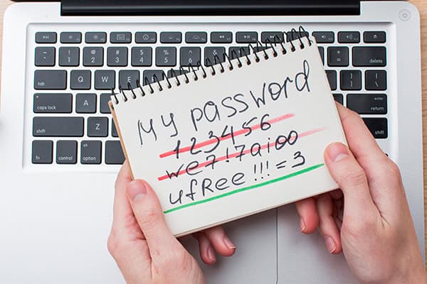 Zwei Hände halten über einer Tastatur einen Block in der Hand mit dem Titel: My Password.
