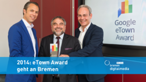 Auf dem Bild sind drei Männer, die in die Kamera schauen und gemeinsam einen Award in Händen halten. Darüber steht auf einem blauen Band: 2014: eTown Award geht an Bremen.