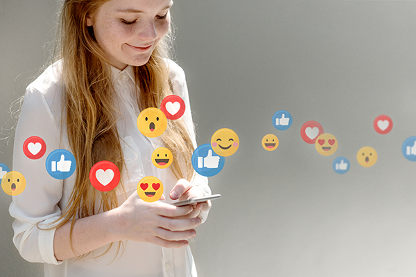 Eine junge Frau schaut auf ihr Smartphone. Über dem Foto laufen Emojis: Herzen, Daumen hoch Smileys.