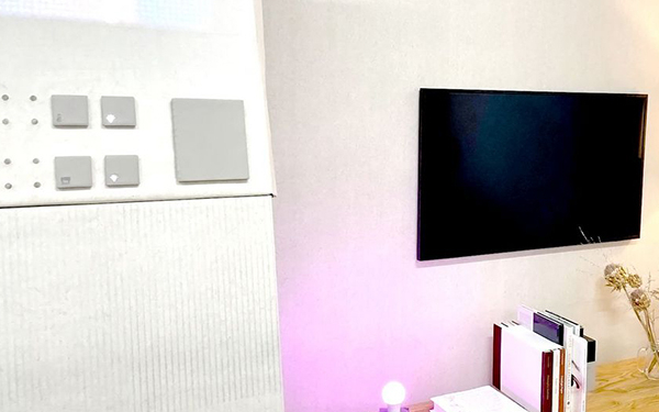 Fotografie einer Zimmerwand, es sind Anschnitte von Möbel, und einem Fernseher erkennbar.