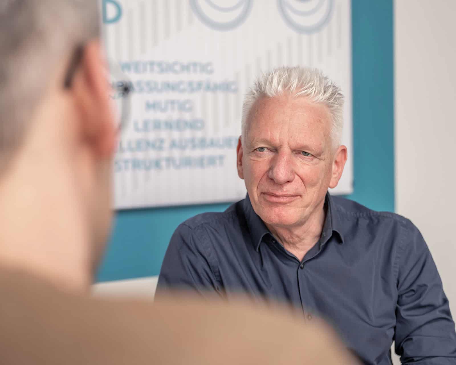 Zwei Männer unterhalten sich miteinander.