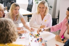 Mehrere Frauen sitzen an einem Tisch und sprechen miteinander.