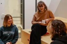 Drei Frauen sitzen in einer Runde und sprechen miteinander.