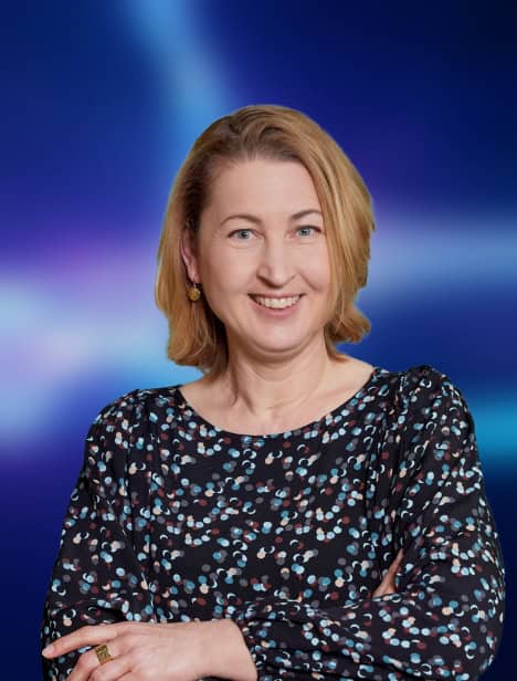 Ausgeschnittenes Porträt einer Frau, die in die Kamera schaut. Der Hintergrund ist blau.