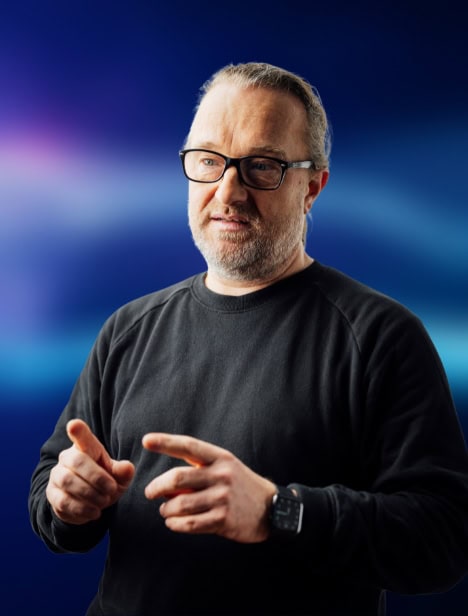 Ausgeschnittenes Porträt eines Mannes, der in seitlich schaut. Der Hintergrund ist blau.