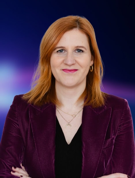 Ausgeschnittenes Porträt einer Frau, die in die Kamera schaut. Der Hintergrund ist blau.