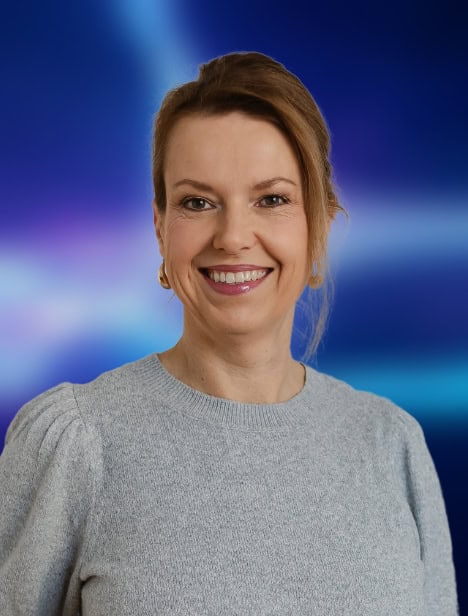 Ausgeschnittenes Porträt einer Frau, die in die Kamera schaut. Der Hintergrund ist blau.