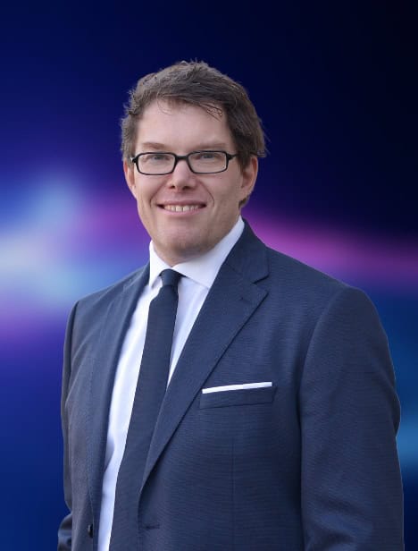 Ausgeschnittenes Porträt eines Mannes, der in die Kamera schaut. Der Hintergrund ist blau.