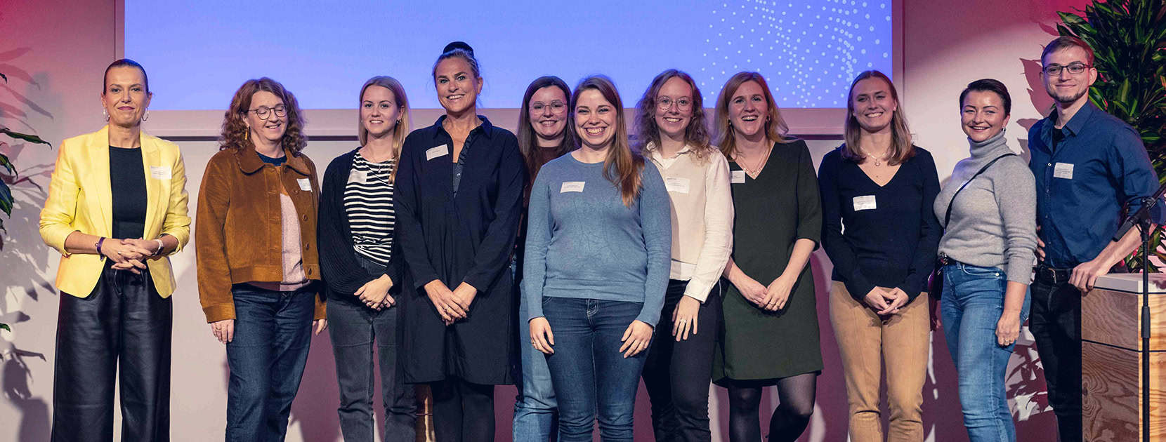 Gruppenfoto von 10 Personen auf einer Bühne.