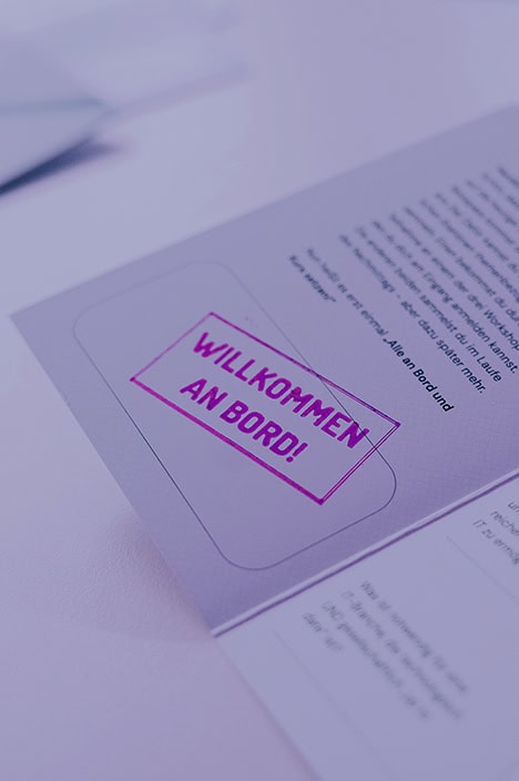 Eine Broschüre mit einem Stempel, der sagt: Willkommen an Bord!