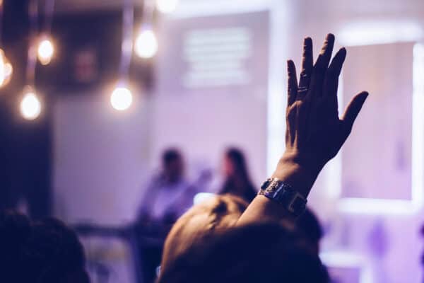 Eine erhobene Hand in einem Publikum.