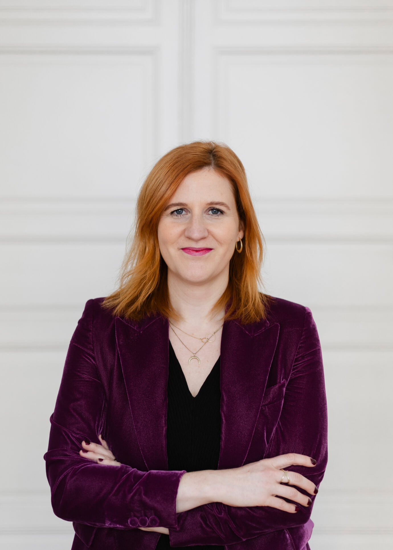 Porträt einer Frau mit verschränkten Armen.