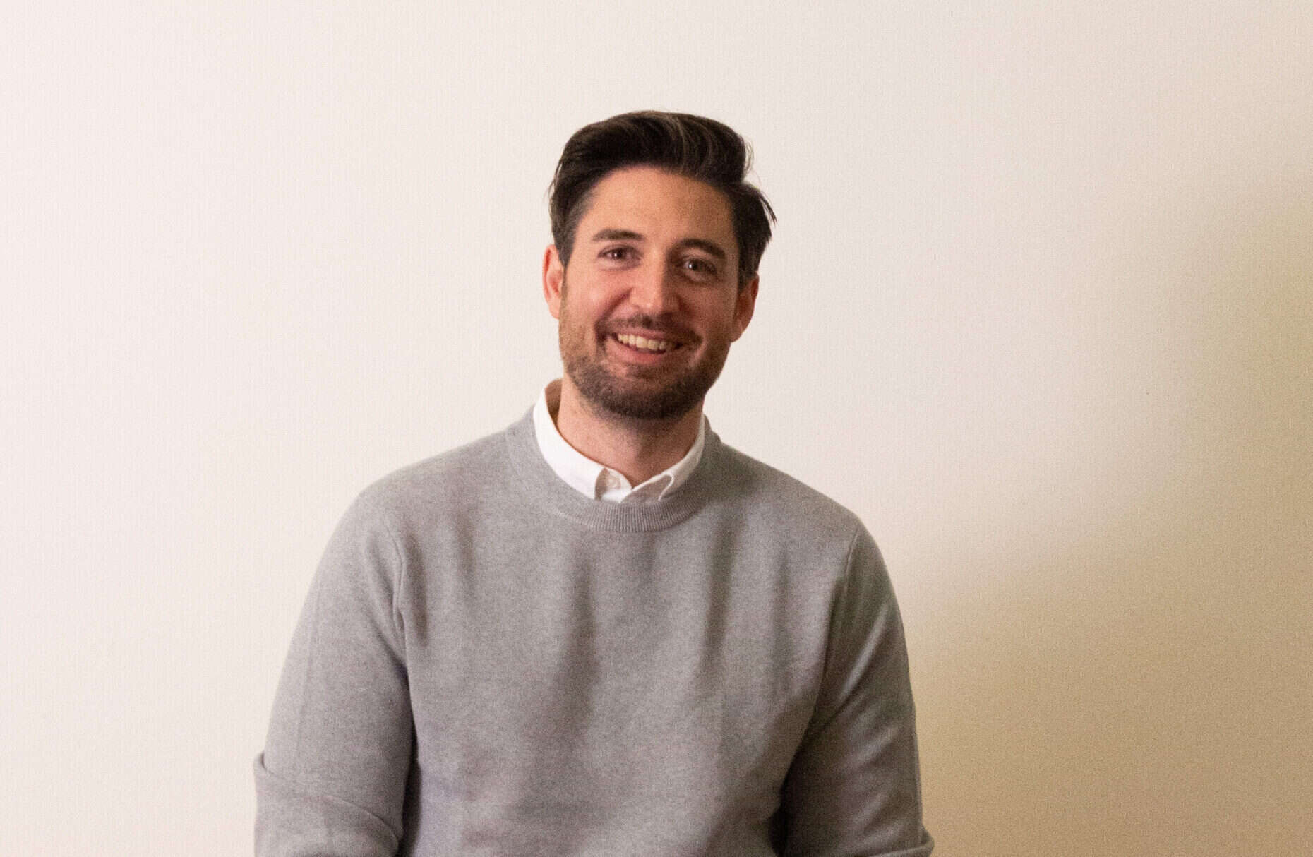 Porträt eines Mannes, der in die Kamera lächelt.