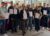 Gruppenfoto mit rund 20 Menschen, die alle je ein Zertifikat in den Händen halten und für ein Gruppenfoto zusammenstehen und in die Kamera gucken.