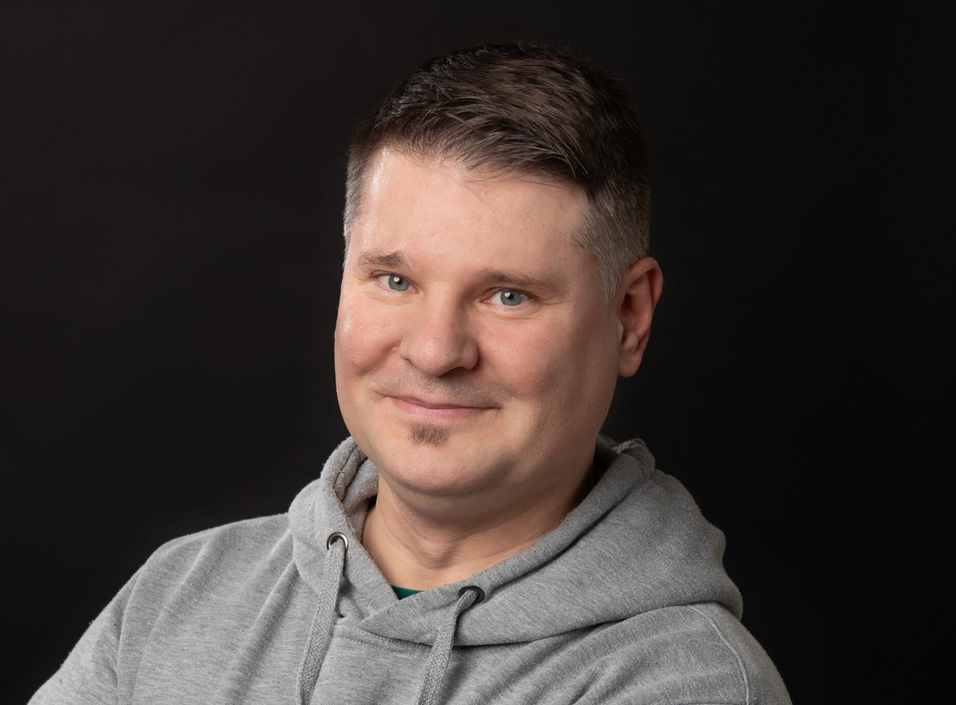 Portraitaufnahme eines Mannes, der in die Kamera lächelt.